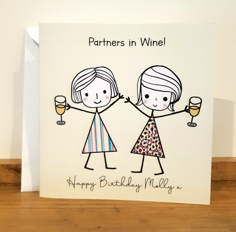Peut inclure: Une carte d'anniversaire avec une illustration de deux amies levant un verre de vin. La carte indique "Partners in Wine!" et "Happy Birthday Molly x".