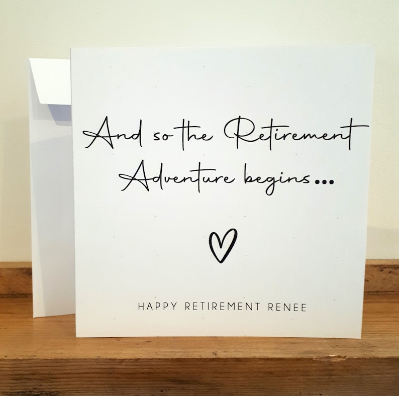 Może przedstawiać: Biała kartka z czarnym tekstem, kt&oacute;ry brzmi "And so the Retirement Adventure begins..." z małym sercem narysowanym pod tekstem. Dolna część kartki brzmi "Happy Retirement Renee".