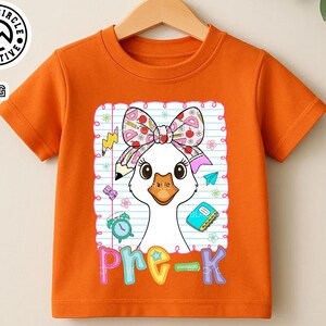 Pode incluir: Camiseta laranja com mangas curtas com um desenho de ganso de desenho animado, um la&ccedil;o, um l&aacute;pis e a palavra "pre-k". O ganso est&aacute; sobre um fundo de papel pautado com ilustra&ccedil;&otilde;es escolares. A camiseta tem gola redonda.