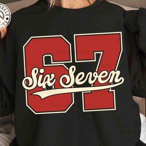 May include: Black sweatshirt featuring a large red number 67 with a white outline. The words "Six Seven" are written in a cursive font across the center of the numbers. The sweatshirt also has the Black Circle Creative logo.