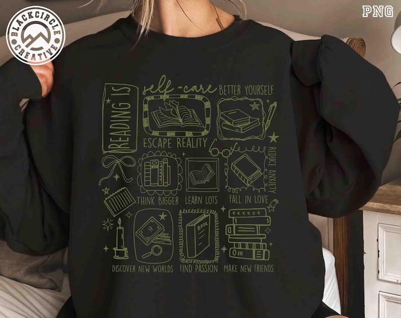 May include: Black sweatshirt with a green graphic design featuring book-related illustrations and text. The text includes phrases like "Reading Is", "Self-Care", "Escape Reality", and "Discover New Worlds".