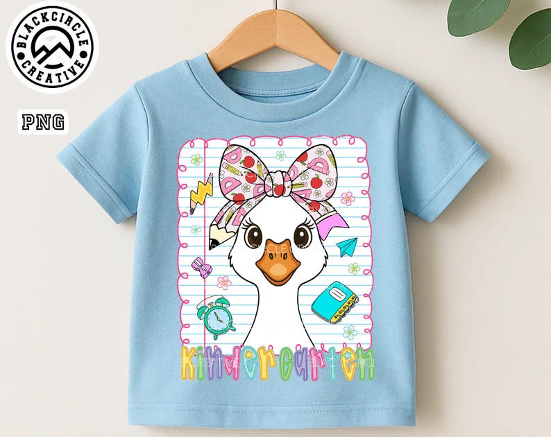 Pode incluir: Camiseta azul claro com um desenho de ganso de desenho animado usando um la&ccedil;o com material escolar. O ganso est&aacute; em frente a um fundo de papel pautado. A palavra "Kindergarten" est&aacute; escrita em letras coloridas na parte inferior.