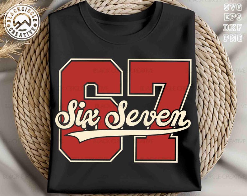 May include: Black t-shirt featuring a red and white graphic of the number "67" with the words "Six Seven" in a vintage font. The design has a retro, collegiate style. The shirt is displayed on a woven surface.