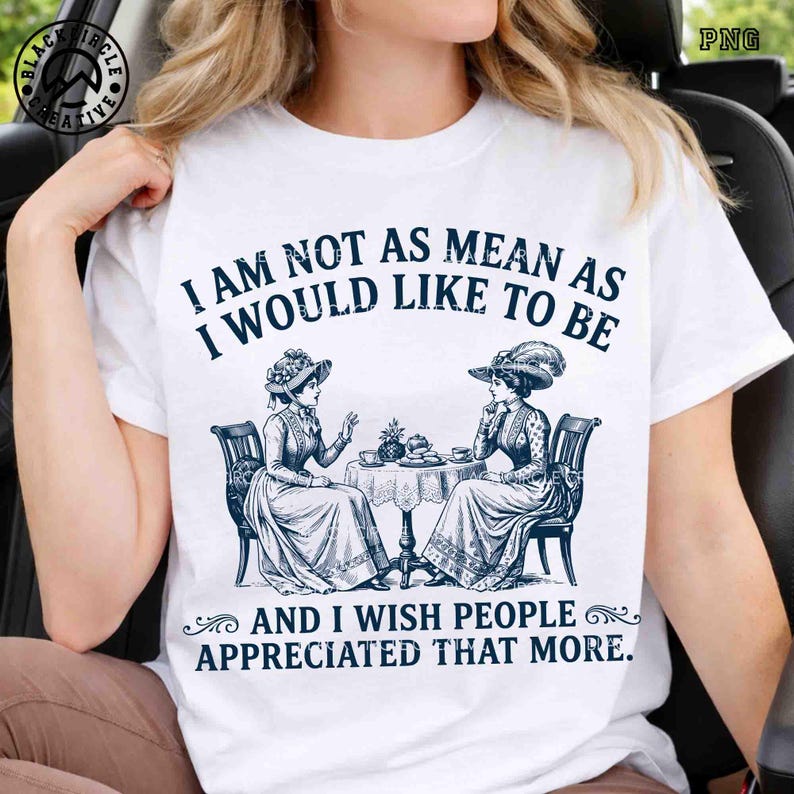 May include: A white short-sleeved t-shirt featuring a dark blue graphic of two women in Victorian-style dresses sitting at a table. The text reads: I AM NOT AS MEAN AS I WOULD LIKE TO BE AND I WISH PEOPLE APPRECIATED THAT MORE.
