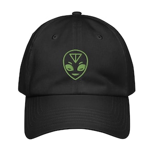 May include: Black baseball cap with a green alien face embroidered on the front. The alien has a triangle on its forehead and closed eyes.