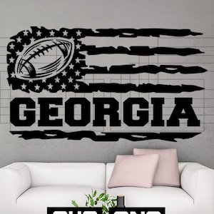 May include: Black and white distressed American flag design with a football and the word "GEORGIA" underneath.