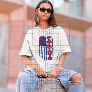 May include: White t-shirt with a distressed American flag design and the word "PATRIOTS" in red and blue lettering.