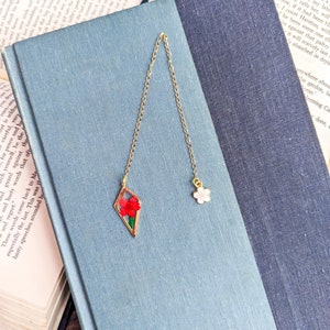 Short gold metal bookmark with two flower charms