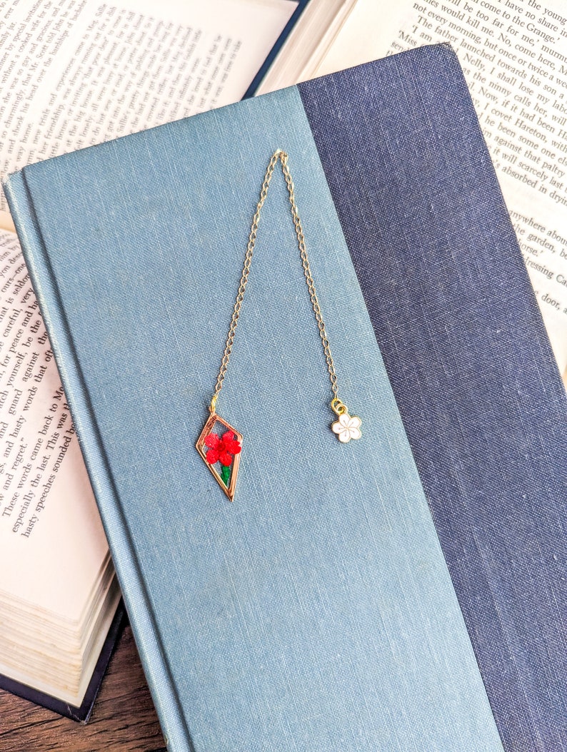 Short gold metal bookmark with two flower charms