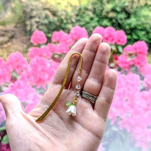 Size of the flower metal hook bookmark in woman's hand.