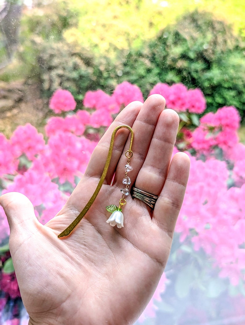 Size of the flower metal hook bookmark in woman's hand.