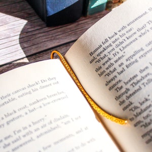 Hook bookmark sitting in an open book.