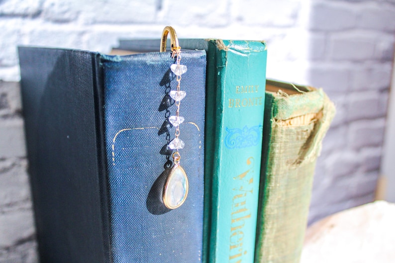 This bookmark has a short crystal and chain dangling over the bookmark.