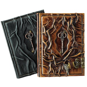May include: Two leather-bound journals, one black and one brown, with embossed designs. Each journal features a decorative key. The brown journal has a clasp with keys. The journals have a vintage, antique aesthetic.