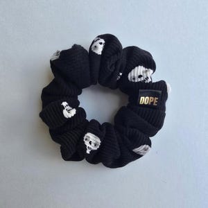 May include: Black scrunchie with white skull print and a gold label that says "DOPE".
