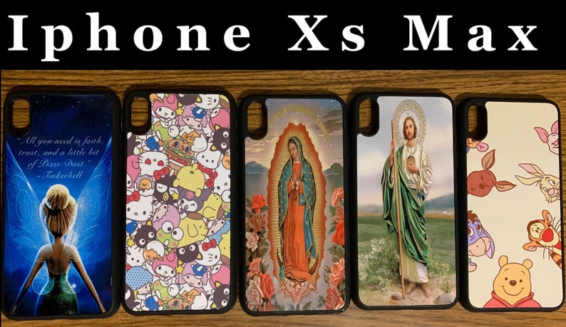 May include: Five different iPhone Xs Max phone cases. The cases are black with a variety of colorful designs. The designs include a Tinkerbell character, a Hello Kitty character, a religious image of the Virgin Mary, a religious image of Jesus, and a Winnie the Pooh character.