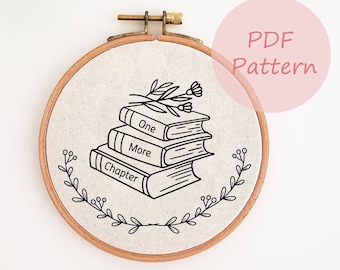 May include: A circular embroidery hoop featuring a beige fabric with a black embroidered design of three stacked books. The books are labelled "One", "More", and "Chapter". A floral design and the words "PDF Pattern" are also visible.