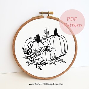 May include: A wooden embroidery hoop with a white fabric featuring a black and white pumpkin design. The design includes three pumpkins, flowers, and leaves. The text "PDF Pattern" is in a pink circle. The website address www.CuteLittleHoop.Etsy.com is at the bottom.