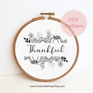 May include: A circular embroidery hoop with a white fabric displaying a black line art design. The design includes pumpkins, sunflowers, leaves, and the word "Thankful". The text "PDF Pattern" is in a pink circle. The website address www.CuteLittleHoop.Etsy.com is at the bottom.