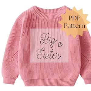 May include: A pink knit sweater with long sleeves. The front features a lighter pink square with the words "Big Sister" in cursive script and a small heart. A yellow starburst graphic with the words "PDF Pattern" is in the upper right corner.