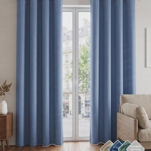 May include: A pair of floor-length, solid blue curtains with silver-toned metal grommets hanging from a horizontal curtain rod. The curtains feature vertical folds and a light-colored hem at the bottom edge, positioned over a glass door frame.