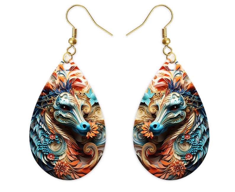May include: A pair of teardrop-shaped earrings with a colorful, intricate design of a dragon's head with blue, orange, and gold accents. The earrings are made of metal with a gold finish.
