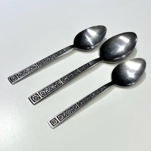 May include: Three silver spoons with a floral pattern on the handle.
