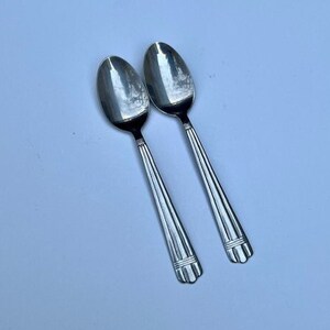 May include: Two silver spoons with ornate handles.