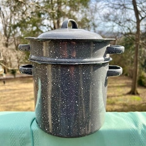 May include: A two-tiered, gray and white speckled enamelware steamer pot with a lid. The pot has two handles on each side.