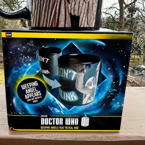 May include: A black Doctor Who Weeping Angels heat reveal mug with the words "Don't Blink" on the side. The mug's packaging features the text "Weeping Angel Appears When Hot Water Is Added."