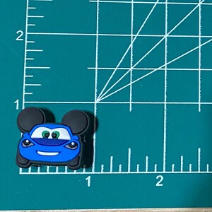 May include: Blue car with Mickey Mouse ears, the car has a smiling face and green eyes.