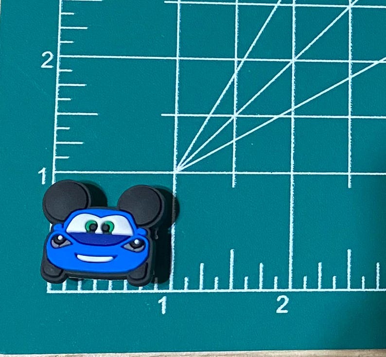 May include: Blue car with Mickey Mouse ears, the car has a smiling face and green eyes.
