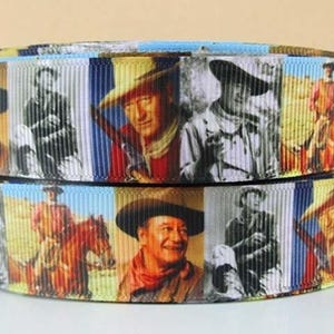May include: A colorful ribbon with a repeating pattern of John Wayne wearing a cowboy hat and various poses. The ribbon features a blue, white, and red striped background.