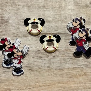May include: Set of five colorful Disney character figurines. Two Mickey Mouse figurines are wearing red and white sailor outfits. Two Minnie Mouse figurines are wearing red and white sailor outfits. One Mickey Mouse figurine is wearing a red and white life preserver.