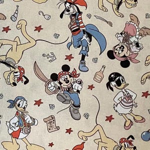 Puede incluir: Una tela beige con un patrón repetido de personajes de Disney vestidos de piratas. Mickey Mouse, Minnie Mouse, el Pato Donald, Goofy y Pluto se representan con accesorios de piratas como parches en el ojo, pañuelos y espadas. El diseño incluye iconos temáticos de piratas.
