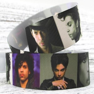 May include: Purple and black ribbon with a repeating pattern of Prince's face in different poses. The ribbon is made of a satin-like material.