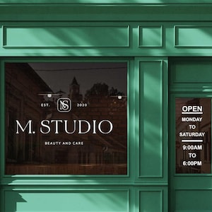 以下が含まれることがあります： 白文字で「M. STUDIO BEAUTY AND CARE」と書かれたターコイズ色の店の正面。お店は月曜日から土曜日の午前9時から午後6時まで営業しています。