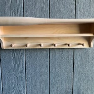 A must-have for sports fans, this baseball bat shelf provides safe storage for homerun baseballs, trophies or your other favorite things.