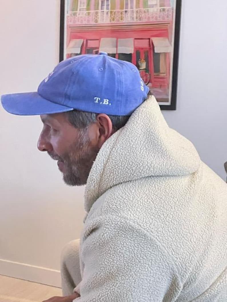 Pu&ograve; includere: Un cappellino da baseball blu con visiera curva. Il cappellino presenta le iniziali "T.B." ricamate in bianco. Il cappellino &egrave; realizzato in un materiale morbido e ha uno stile classico e casual.