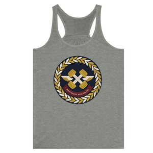 May include: A heather gray racerback tank top featuring a circular emblem on the chest. The emblem displays two crossed gold dumbbells with white wings, surrounded by a laurel wreath and a maroon banner with the text PREFLIGHT DISCIPLINE.
