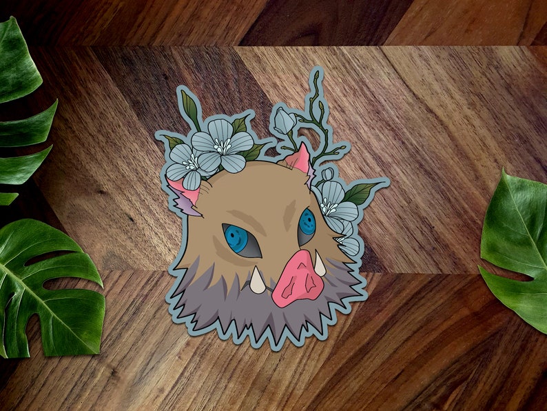 May include: A blue and brown cartoon boar head with a crown of blue flowers. The boar has a pink snout and sharp teeth. The boar's eyes are blue and have a white highlight.
