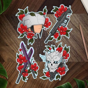 May include: Four sticker designs featuring floral patterns with different characters. The first sticker shows a white helmet with a face inside. The second sticker shows a black and grey rifle. The third sticker shows two crossed swords. The fourth sticker shows a white skull with a blue and white design.