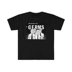 May include: Black and white illustration of a band called "The Germs" with the text "What God Means to Me..." above the band name. The band members are wearing clothing and have short hair.