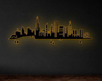 May include: Black silhouette of the Chicago skyline with a Ferris wheel, against a dark gray background. The skyline is illuminated with a yellow glow.