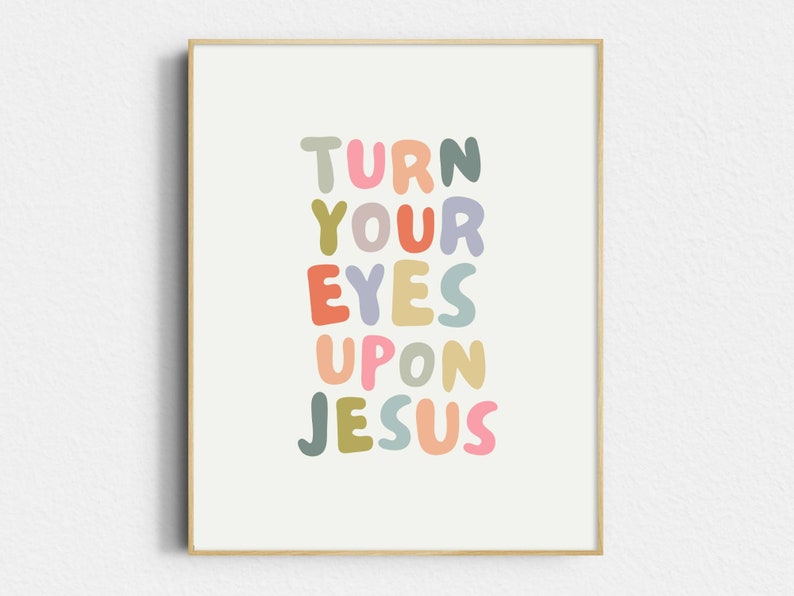 May include: A framed art print with the words "TURN YOUR EYES UPON JESUS" in colorful, rounded letters. The text is arranged vertically on a cream-colored background, framed by a light wood border.