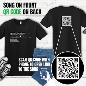 Peut inclure: T-shirt noir avec un code QR au dos et un titre de chanson et un artiste sur le devant. Le texte sur le devant indique "Together in Electric Dreams" par "Giorgio Moroder et Philip Oakey". Le texte comprend également "We'll always be together" et "Together in Electric Dreams".
