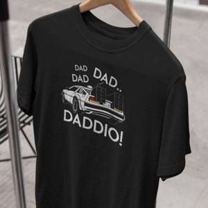 Könnte beinhalten: Schwarzes T-Shirt mit einem weißen Aufdruck eines Autos und dem Text "DAD DAD DADDIO!"