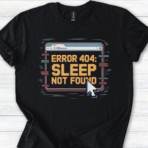 Könnte beinhalten: Schwarzes T-Shirt mit einem pixeligen Bild eines Computerbildschirms, auf dem der Text "FEHLER 404: SCHLAF NICHT GEFUNDEN" steht.