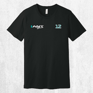 Puede incluir: Camiseta negra con la palabra "ANT" en verde azulado y blanco, y el número "12" en verde azulado. La camiseta tiene cuello redondo y mangas cortas. El texto "ANT" está encima de un texto más pequeño en cursiva.