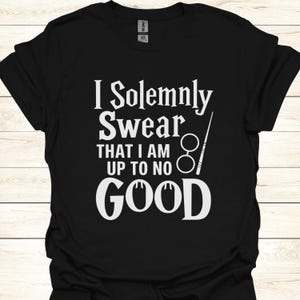 Può includere: Maglietta nera con testo bianco che recita "I Solemnly Swear That I Am Up To No Good" con un paio di occhiali e una bacchetta.